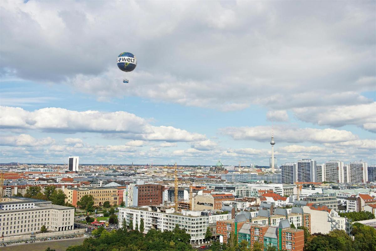 horkovzdušný balón letící nad městem