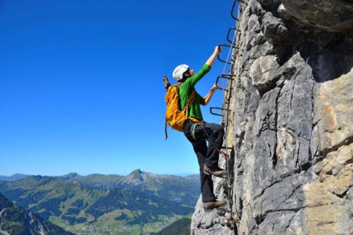 a man on a rock climbing on a mountain