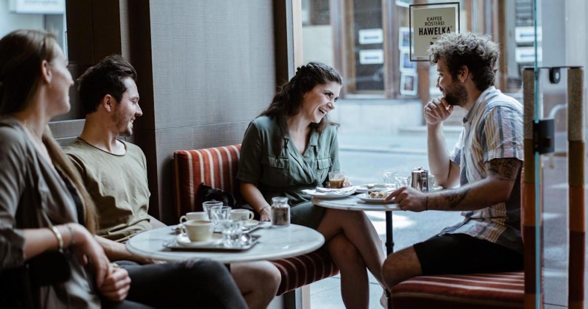 skupina lidí sedících kolem stolu v restauraci