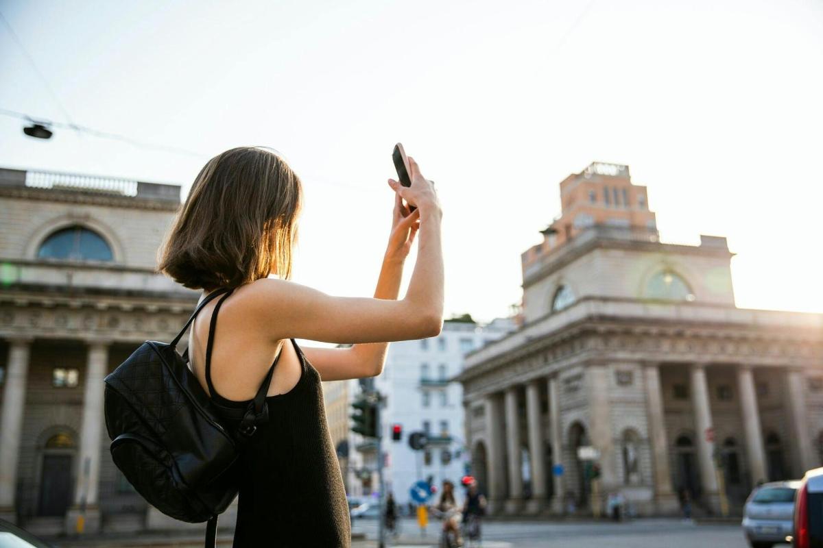 žena fotící ulici mobilním telefonem