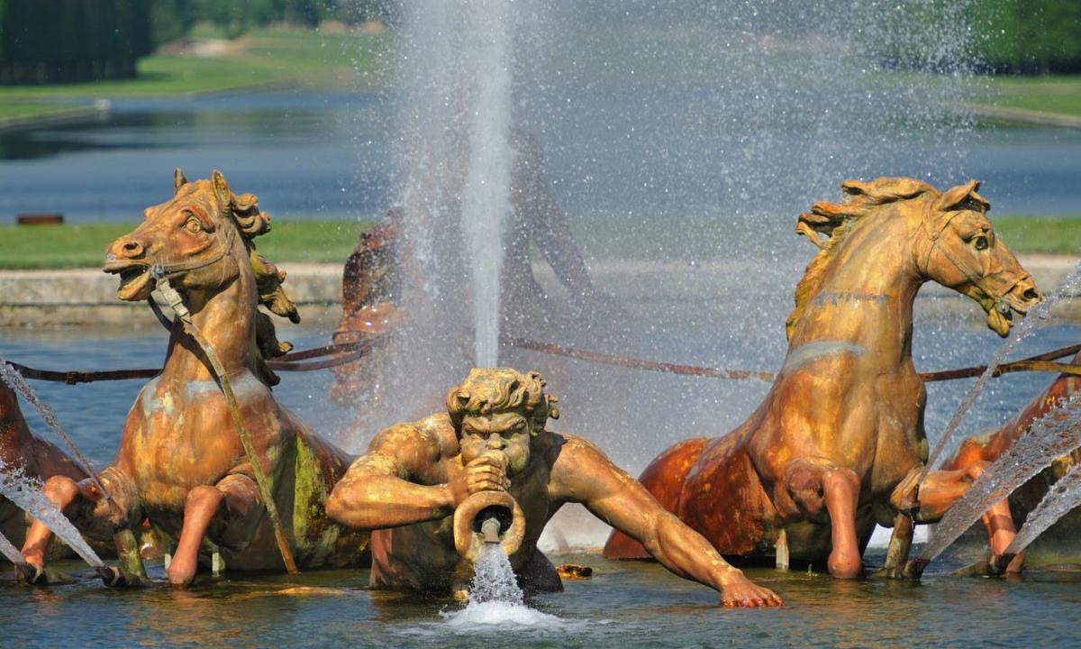 a fountain with three horses in the water