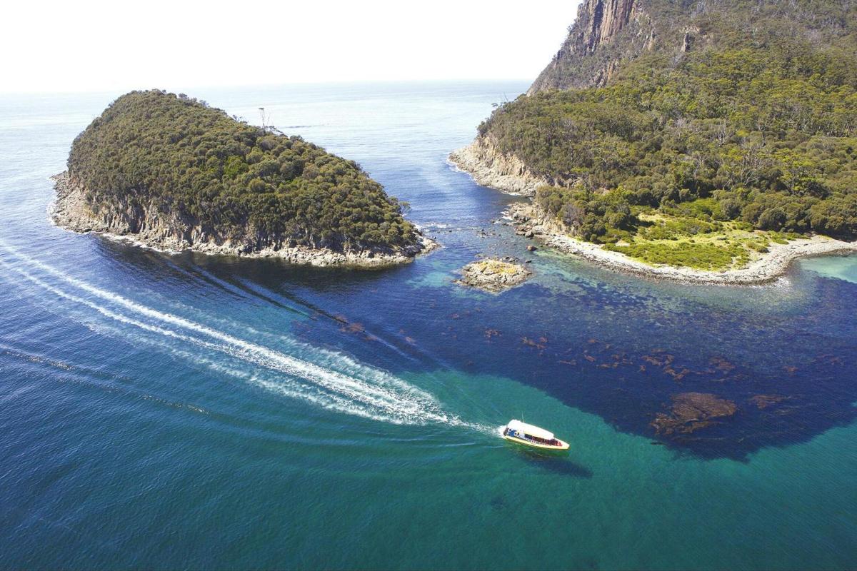 una barca in acqua vicino a una piccola isola