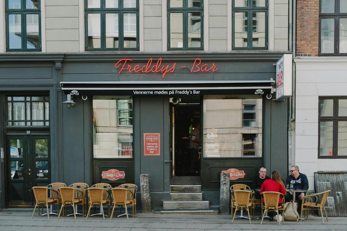 a group of people sitting outside of a restaurant