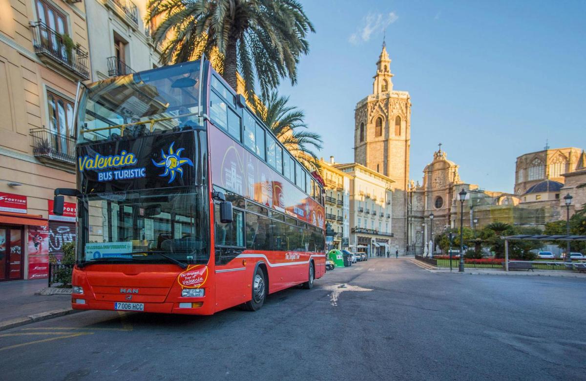 červený dvoupatrový autobus jedoucí po městské ulici