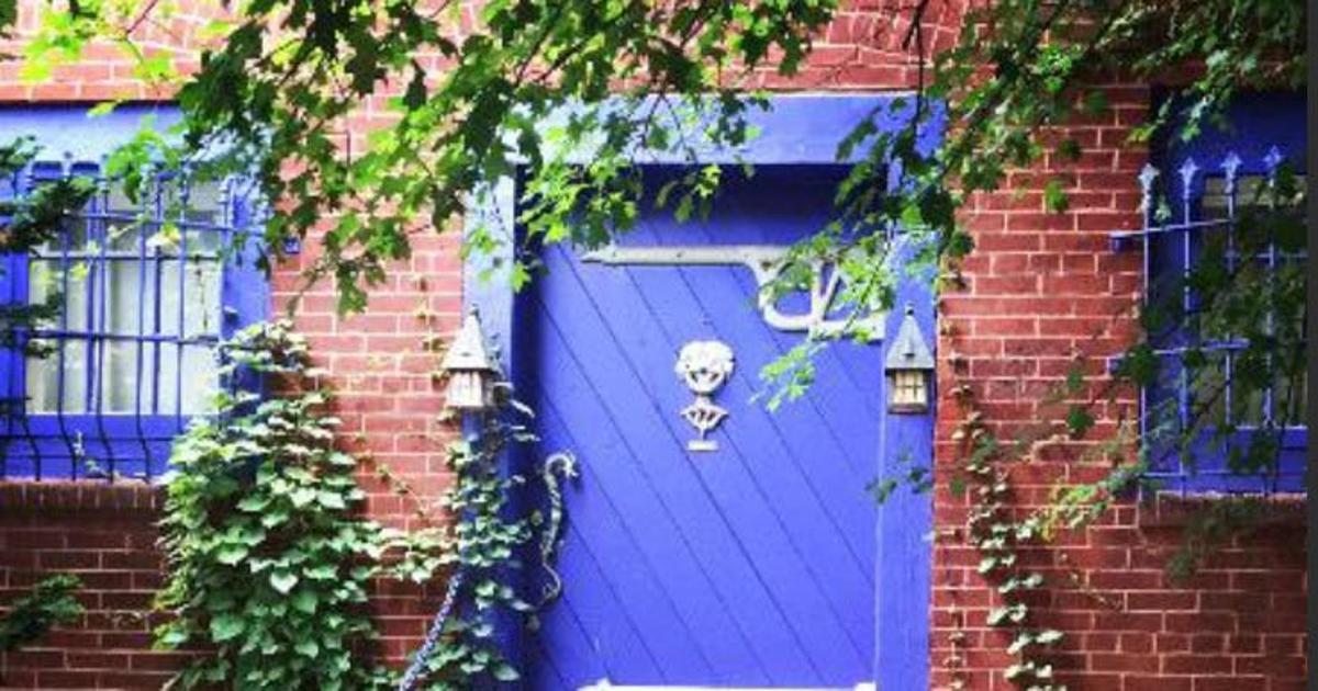 pintu biru dengan tengkorak di atasnya pada bangunan bata