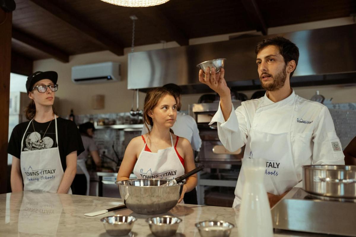 um grupo de três chefs em pé em uma cozinha