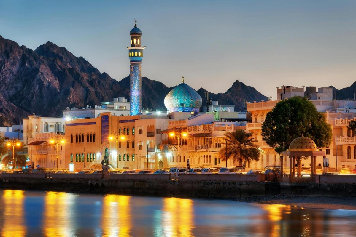 a city with a mosque in front of a mountain