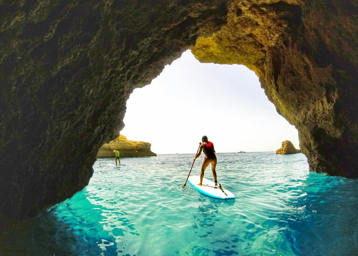 una persona su una tavola da paddle nell'acqua di una grotta