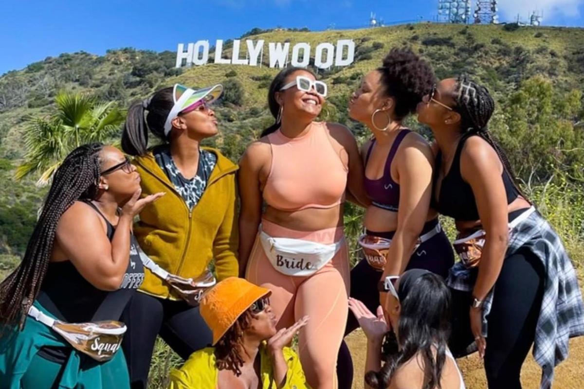 Skupina žen stojících před hollywoodským nápisem