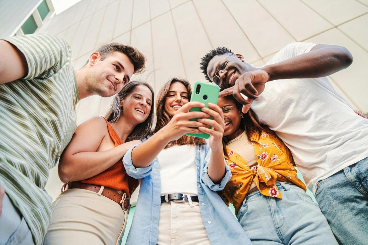 skupina ljudi, ki se fotografirajo z mobilnim telefonom