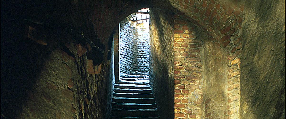 an alley with a brick tunnel with a window