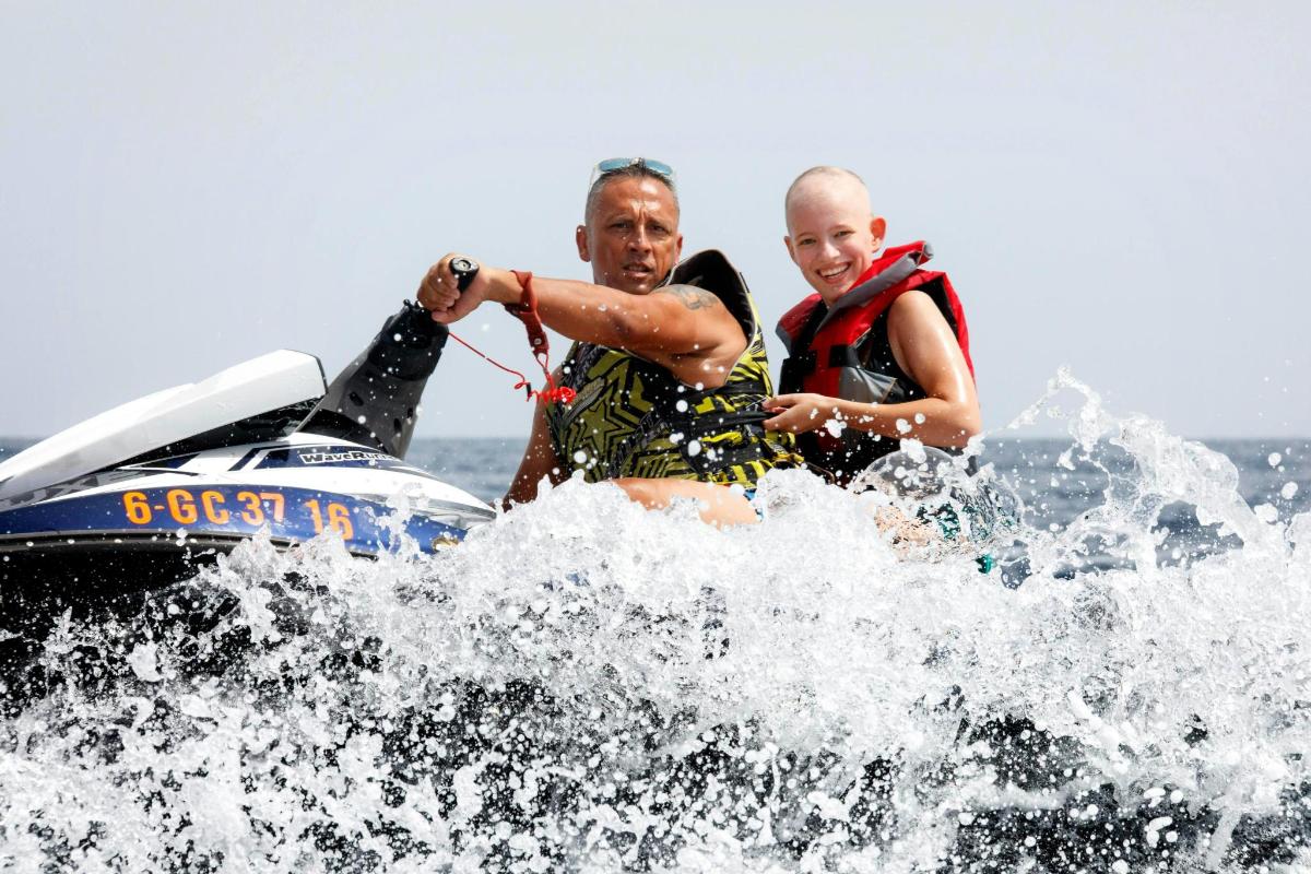 seorang lelaki dan seorang kanak-kanak menaiki jet ski di dalam air