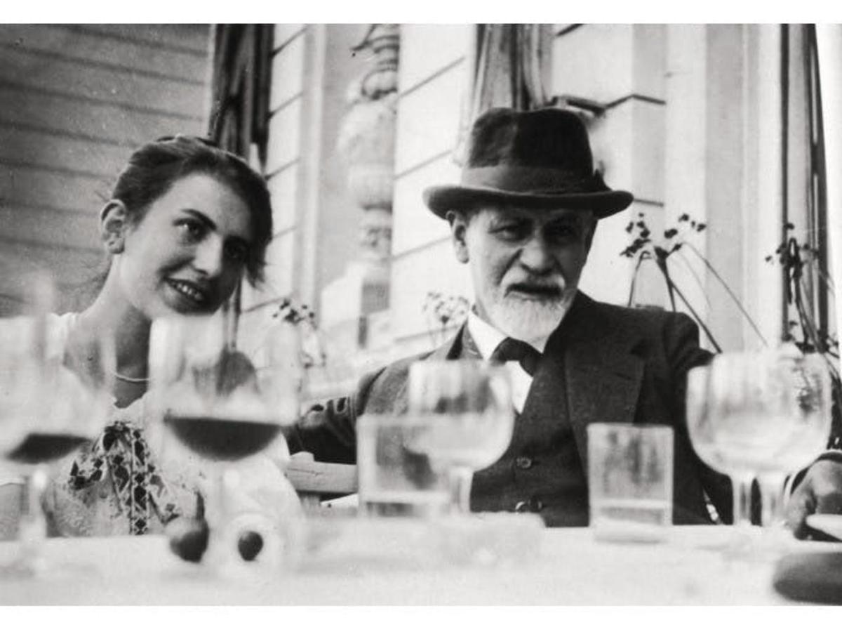 um homem e uma mulher sentados à mesa com taças de vinho
