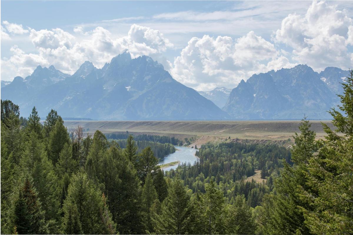 una vista di una valle con un fiume e montagne