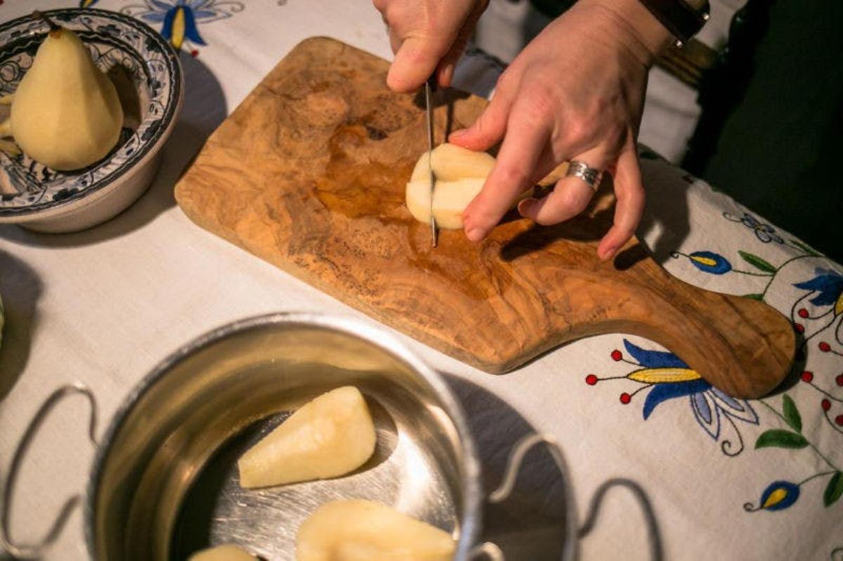 osoba koja reže hranu na drvenoj dasci za rezanje