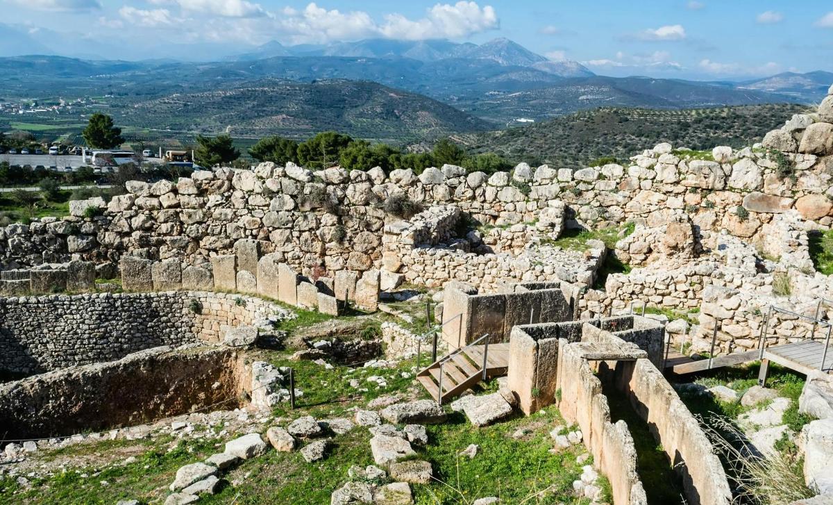 antiche rovine su una collina con montagne sullo sfondo