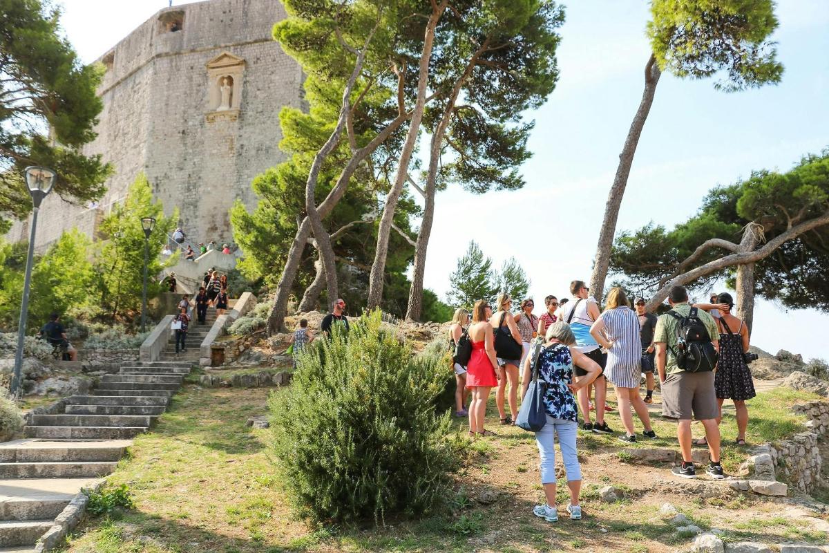 μια ομάδα ανθρώπων που στέκονται έξω από ένα κάστρο