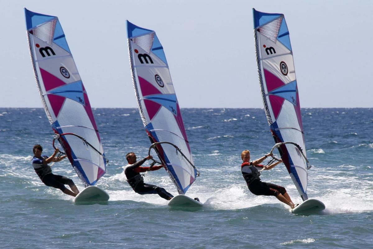 Un grupo de personas haciendo windsurf en el océano
