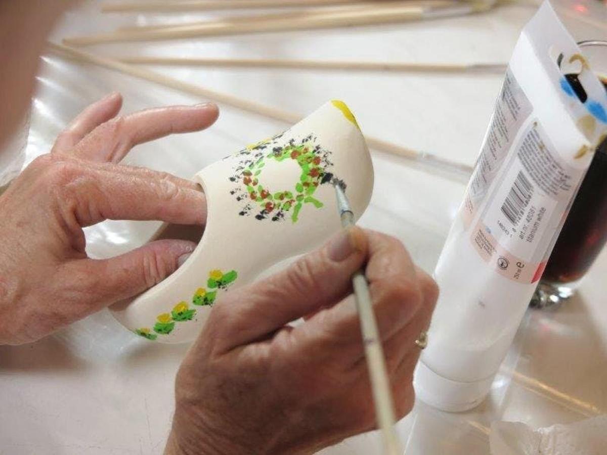 людина, яка ріже аркуш паперу ножицями