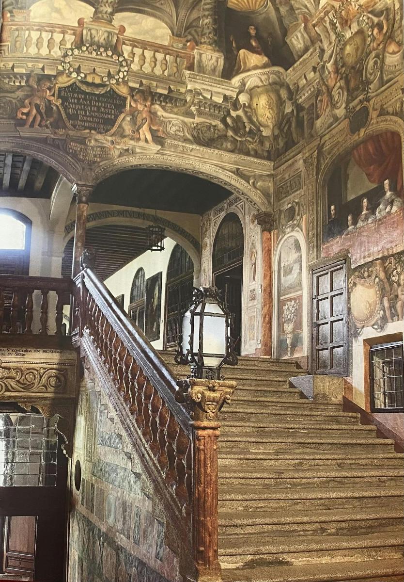 a staircase in a building with paintings on the ceilings