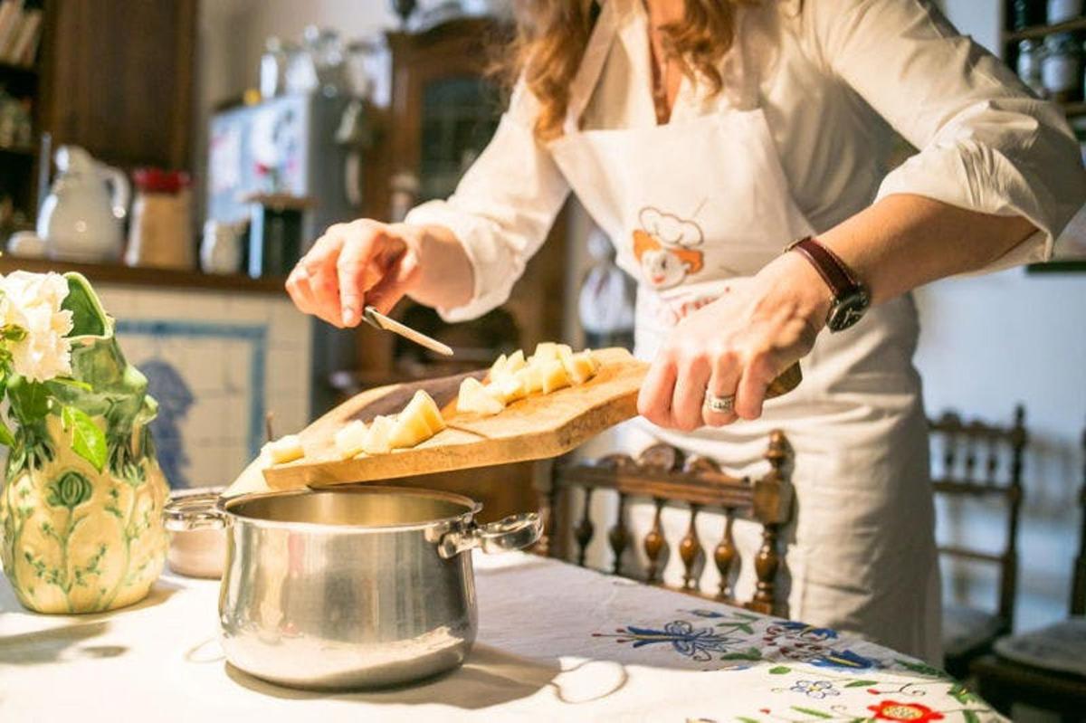 uma mulher em uma cozinha preparando comida em uma mesa