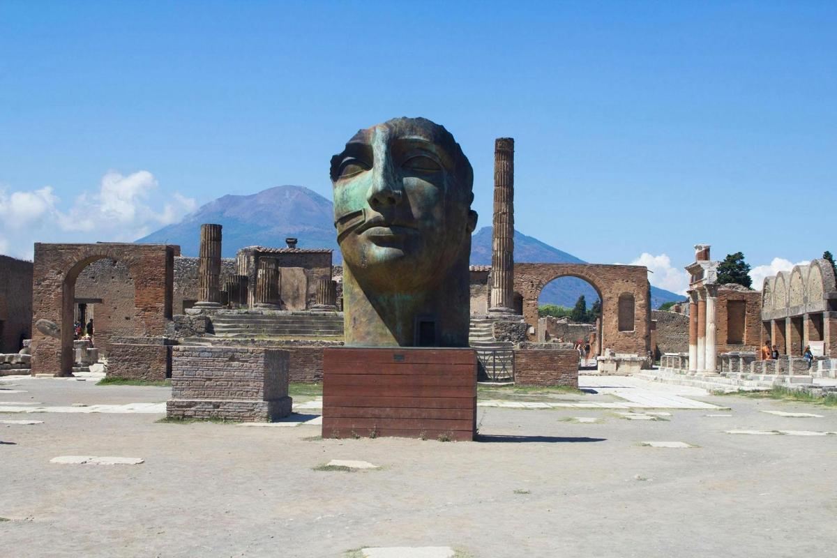 Una gran estatua de una cara frente a un edificio.