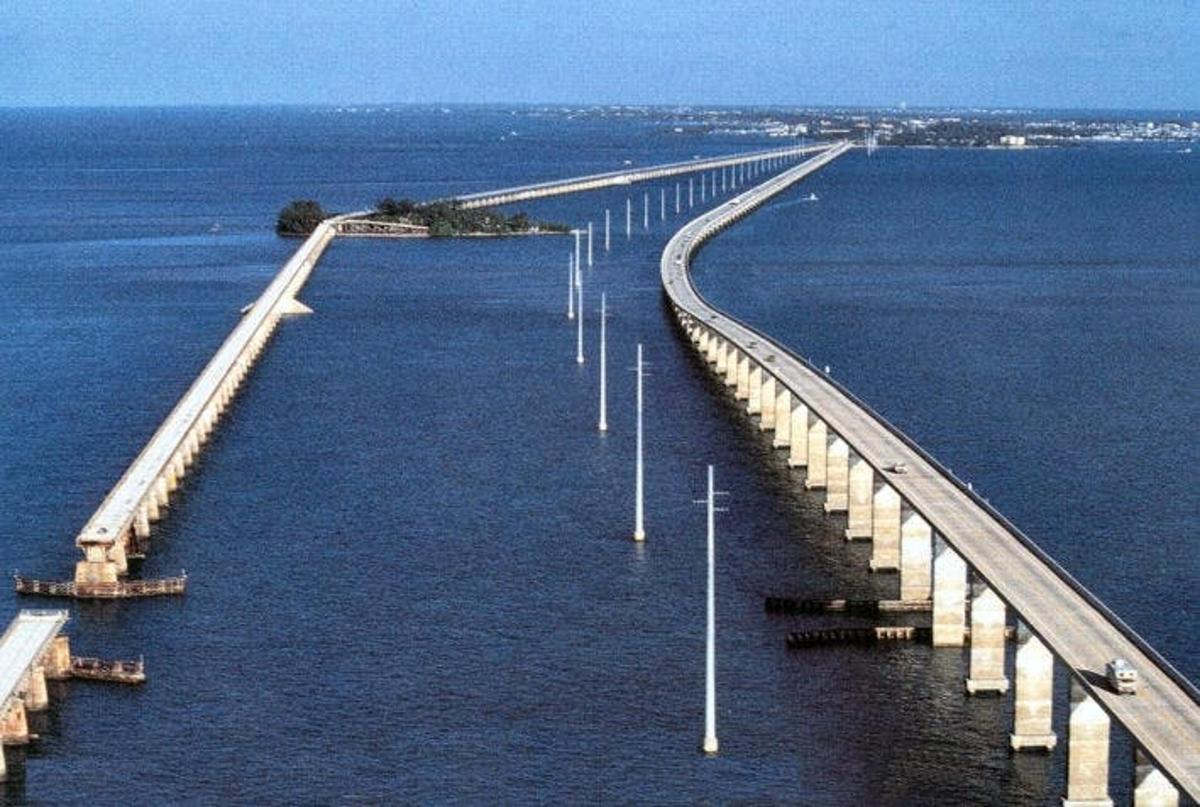 a long bridge in the water with cars on it