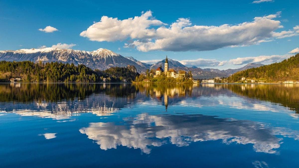un reflex d'un castell en un llac amb muntanyes