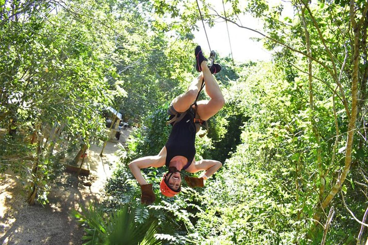 a woman is hanging from a rope in the trees