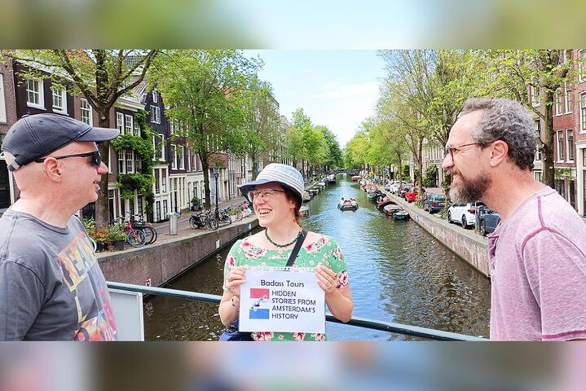 Dos hombres y una mujer sosteniendo un cartel junto a un canal