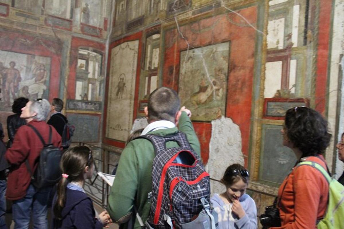 žmonių grupė, apžiūrinėjanti paveikslą muziejuje