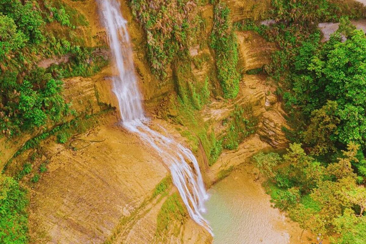 an aerial view of a waterfall on the side of a mountain