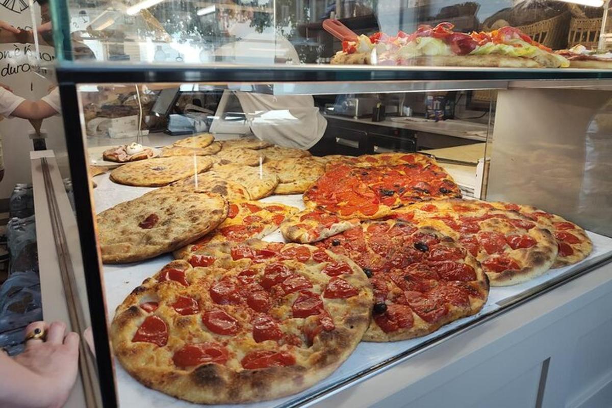 o vitrină cu multe tipuri diferite de pizza expuse