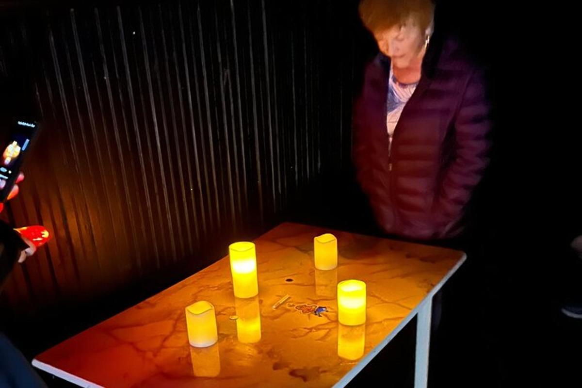 una donna in piedi accanto a un tavolo con sopra delle candele gialle