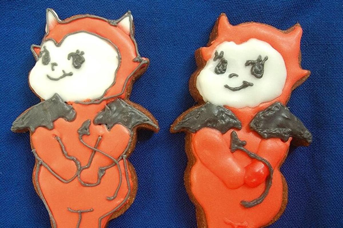 dois biscoitos de gengibre com gatos pintados neles