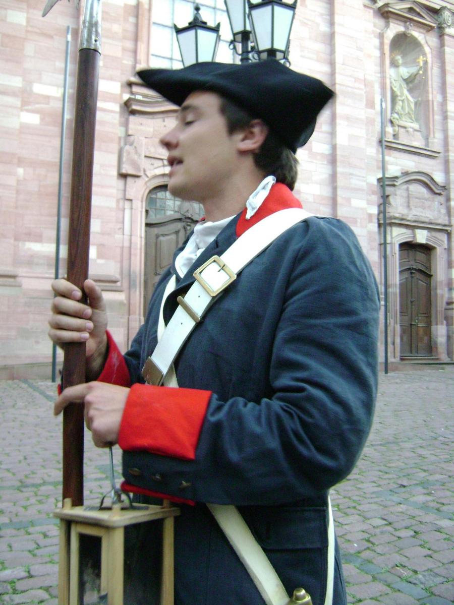a man dressed in a uniform holding a stick