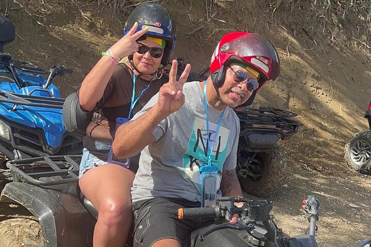 dua lelaki duduk di atas atv dalam tanah