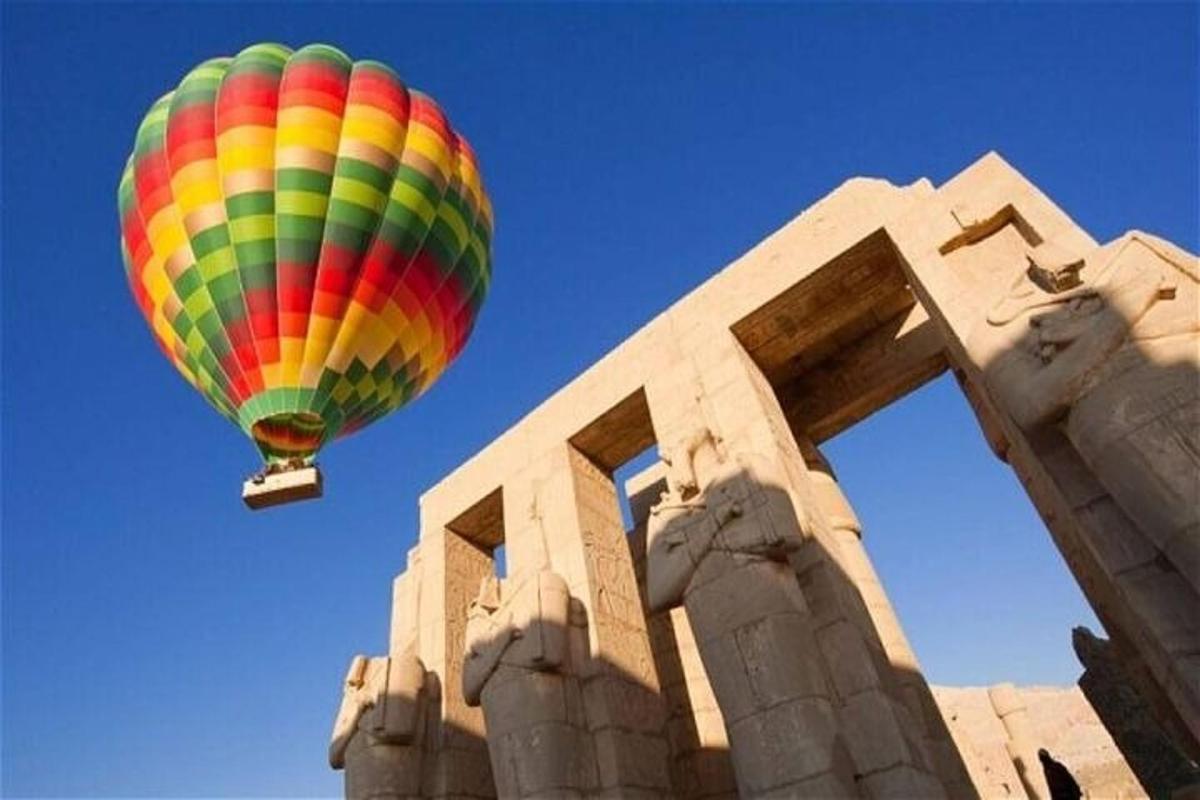 egy színes hőlégballon repül egy épület felett