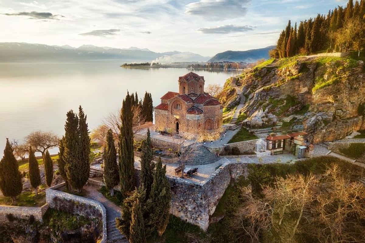 una vecchia chiesa su una collina accanto a uno specchio d'acqua