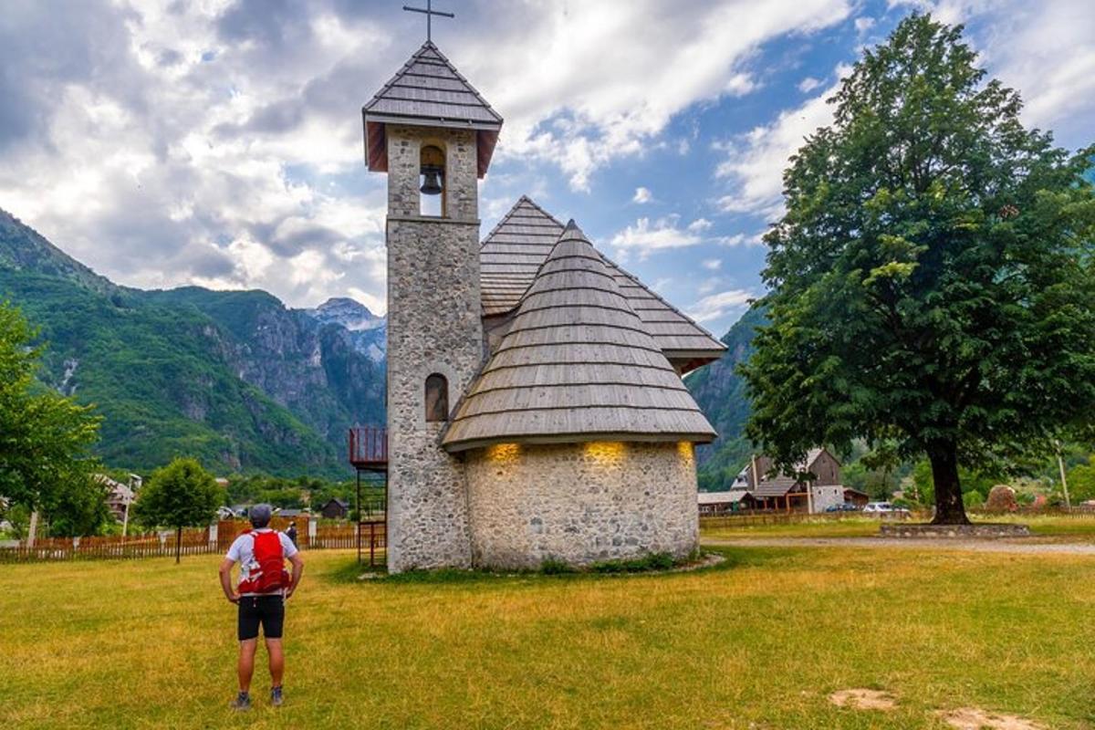 čovjek stoji ispred male crkve