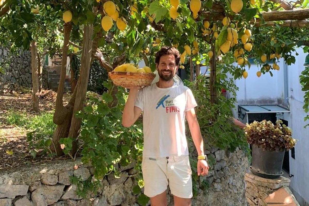 Ένας άντρας κρατάει ένα καλάθι με φρούτα κάτω από ένα δέντρο