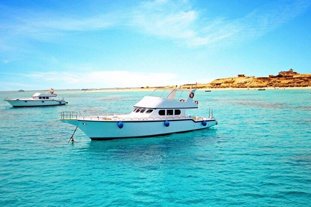 due barche che galleggiano nell'acqua vicino a una spiaggia