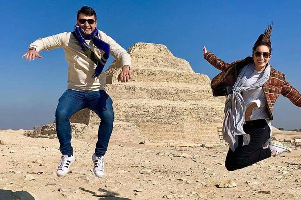 To personer poserer foran en pyramide