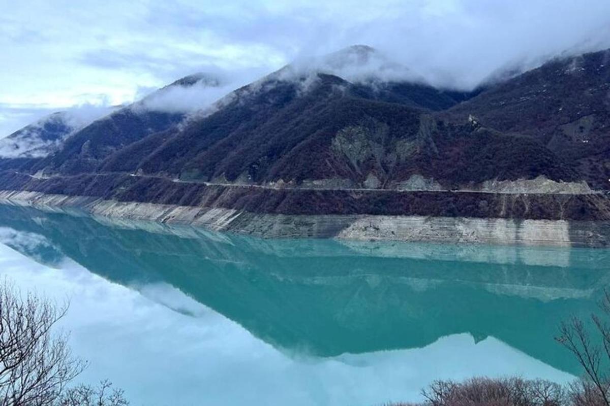 uno specchio d'acqua con una montagna sullo sfondo
