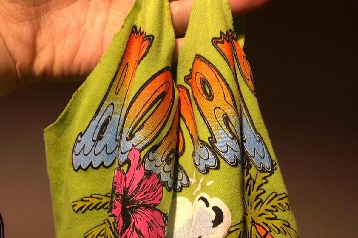 una mano che tiene una cravatta verde con dei disegni sopra
