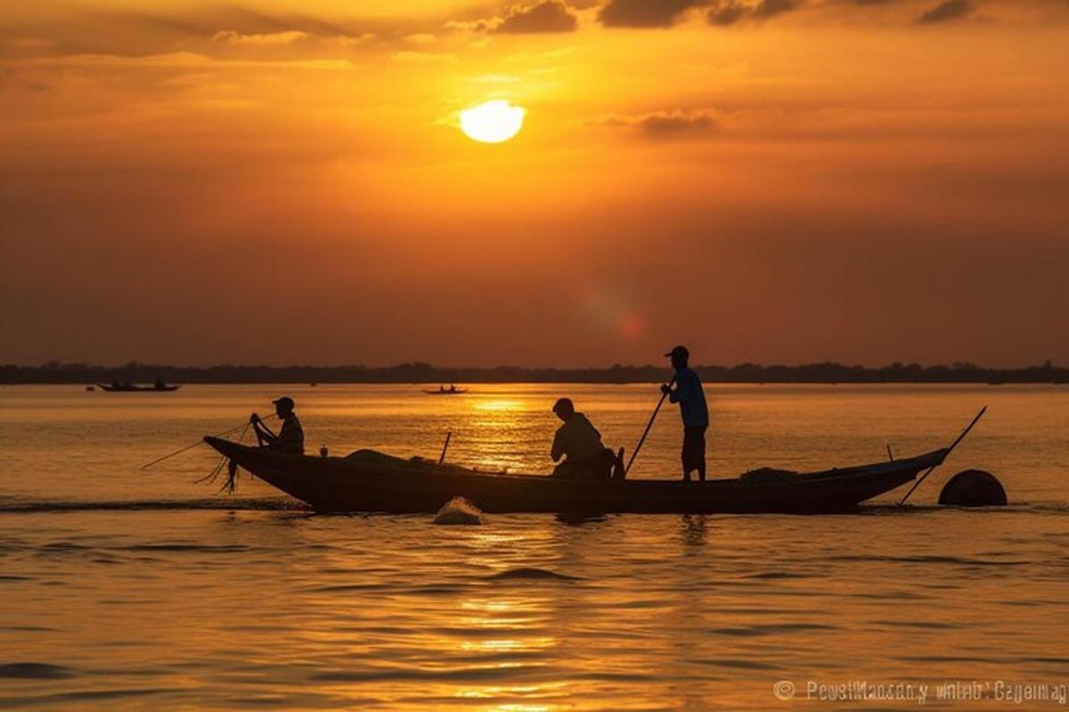drie mensen in een boot op het water bij zonsondergang