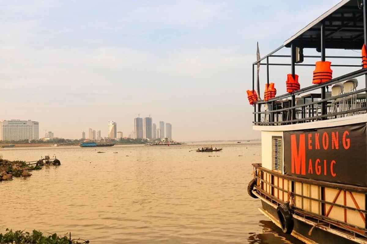 een veerboot op een rivier met een stad op de achtergrond