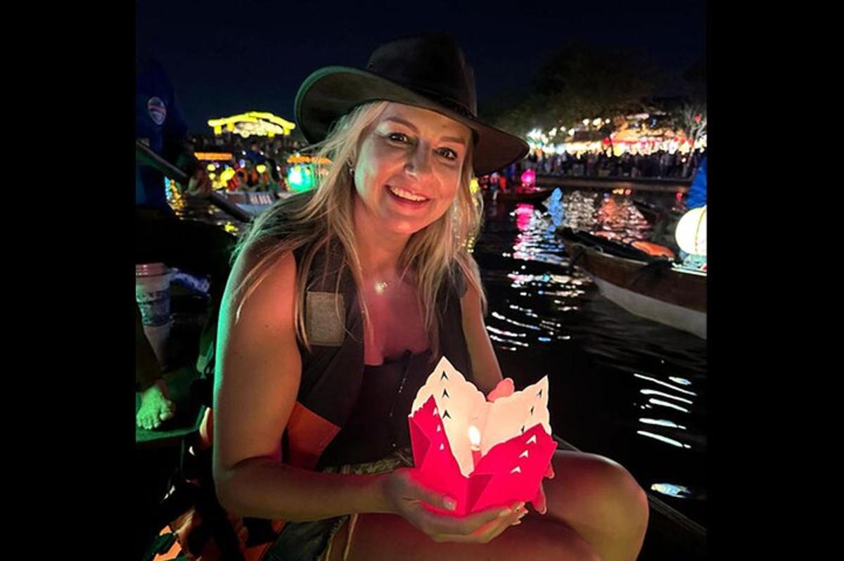 una donna con un cappello tiene in mano un pezzo di carta
