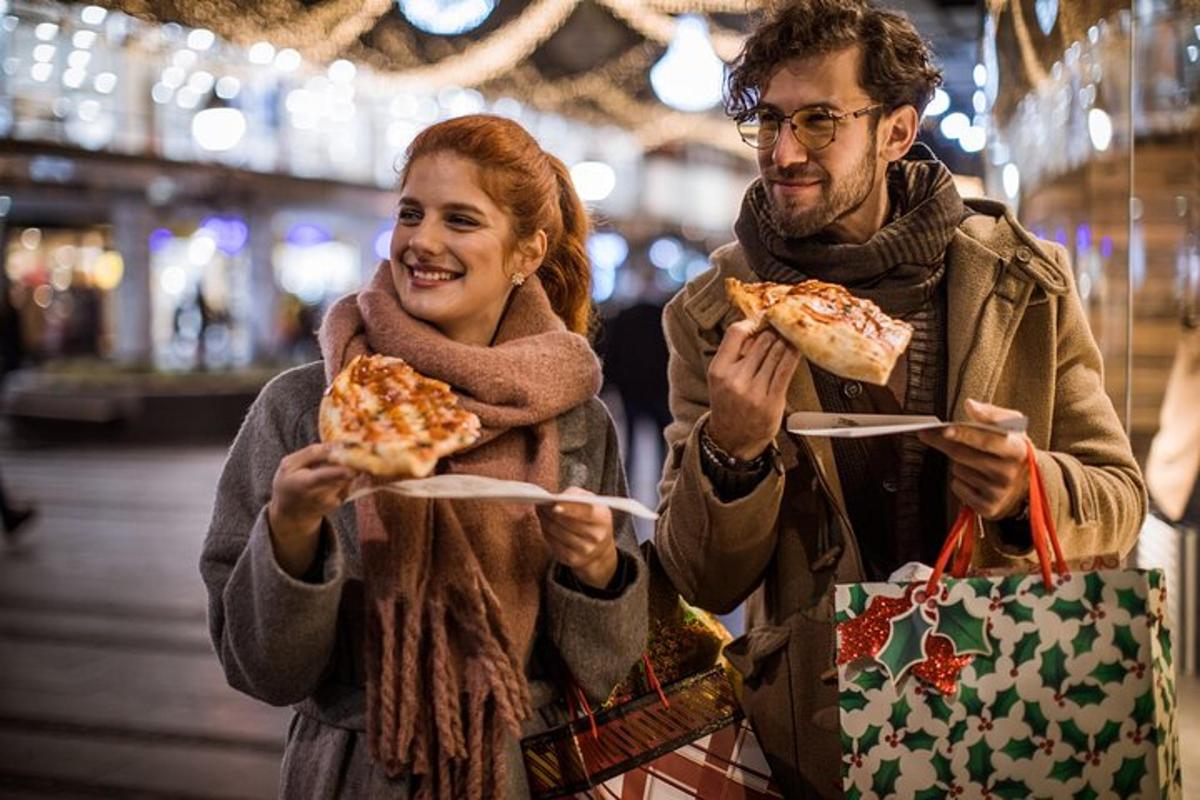 un uomo e una donna che tengono in mano due fette di pizza