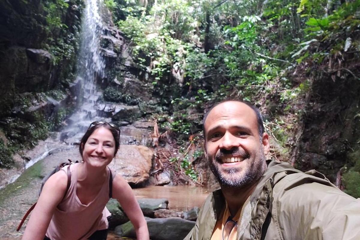 seorang lelaki dan seorang wanita berdiri di hadapan air terjun